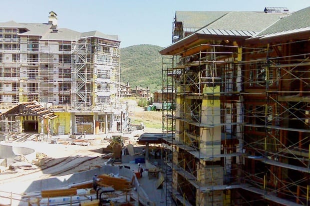 A towering construction site with scaffolding surrounding a massive building in progress.